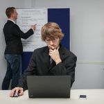 A woman sitting at a desk with a laptop computer