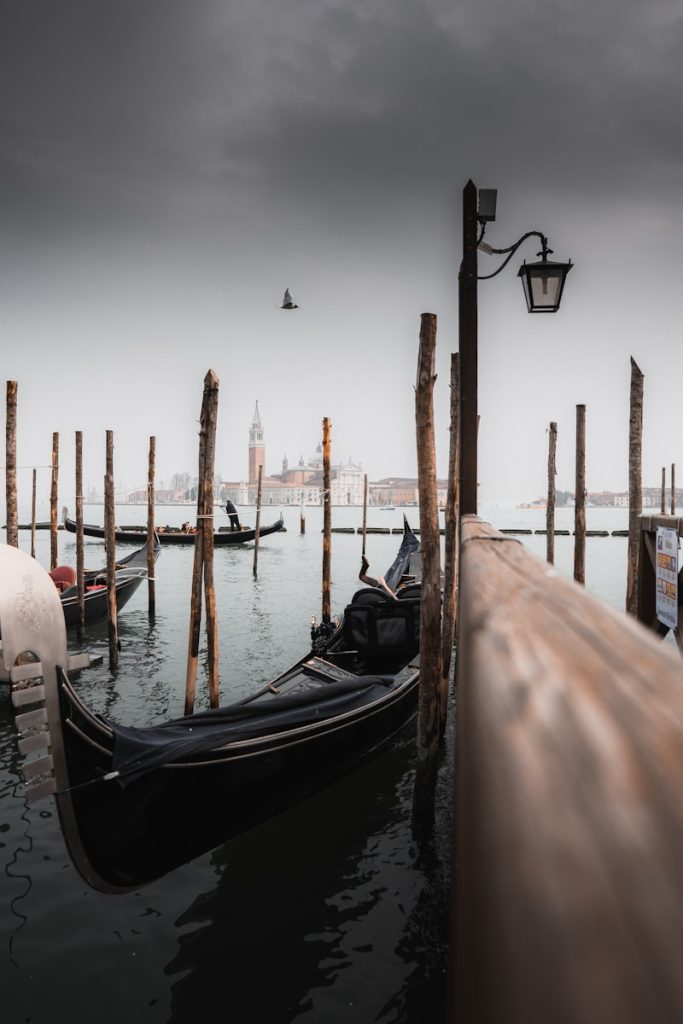 A row of gondolas sitting next to a wooden pier