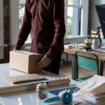 person holding cardboard box on table