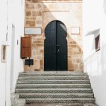 A set of stairs leading up to a black door