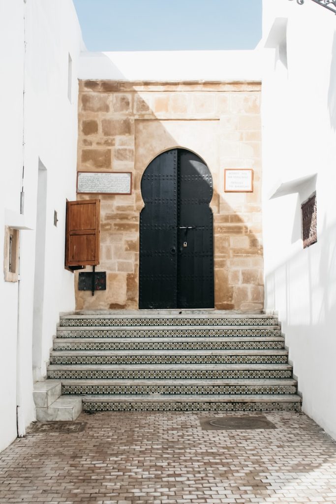 A set of stairs leading up to a black door