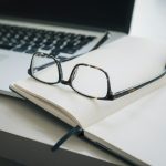 black framed eyeglasses and black pen