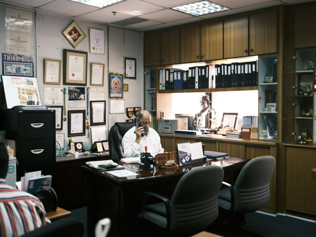 man in white dress shirt sitting on black office rolling chair